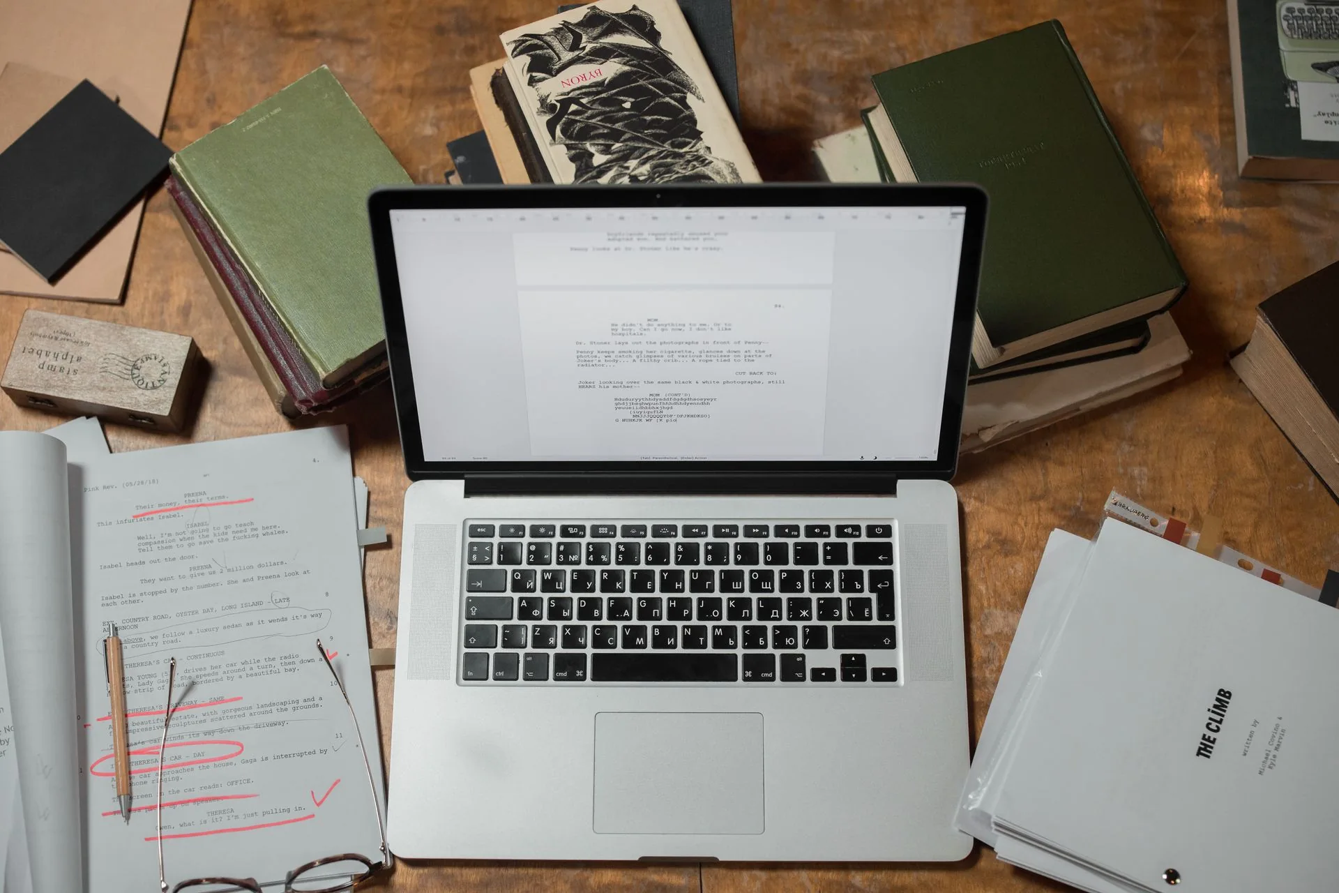 Livros e documentos organizados ao redor de um notebook.